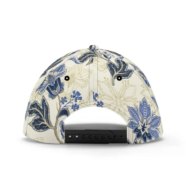 Gorra de béisbol con estampado floral vintage en azul y dorado, mostrando detalles de paisley y visera pre-curvada para protección solar.