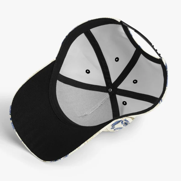 Gorra de béisbol con estampado floral vintage en azul y dorado, mostrando detalles de paisley y visera pre-curvada para protección solar.