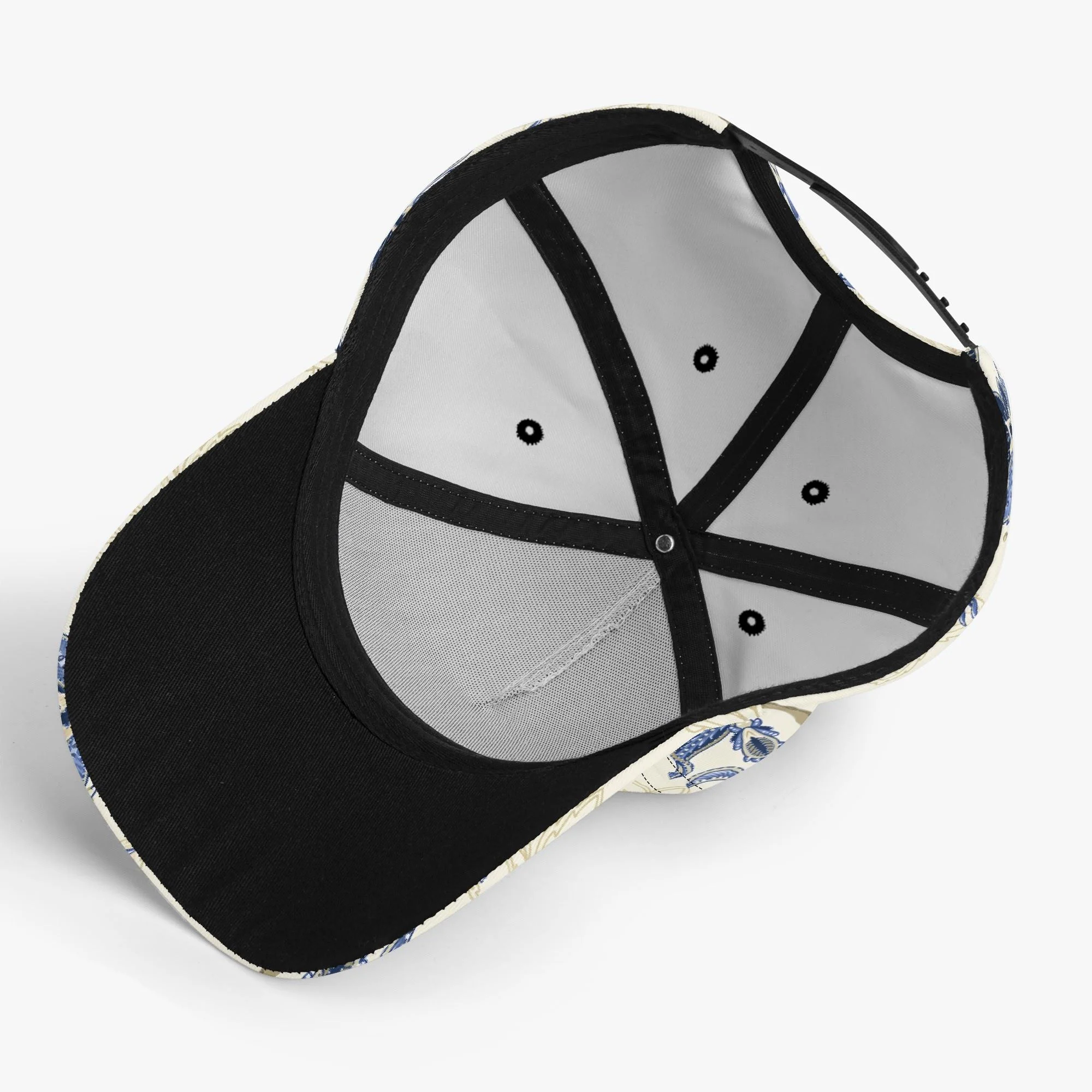 Gorra de béisbol con estampado floral vintage en azul y dorado, mostrando detalles de paisley y visera pre-curvada para protección solar.