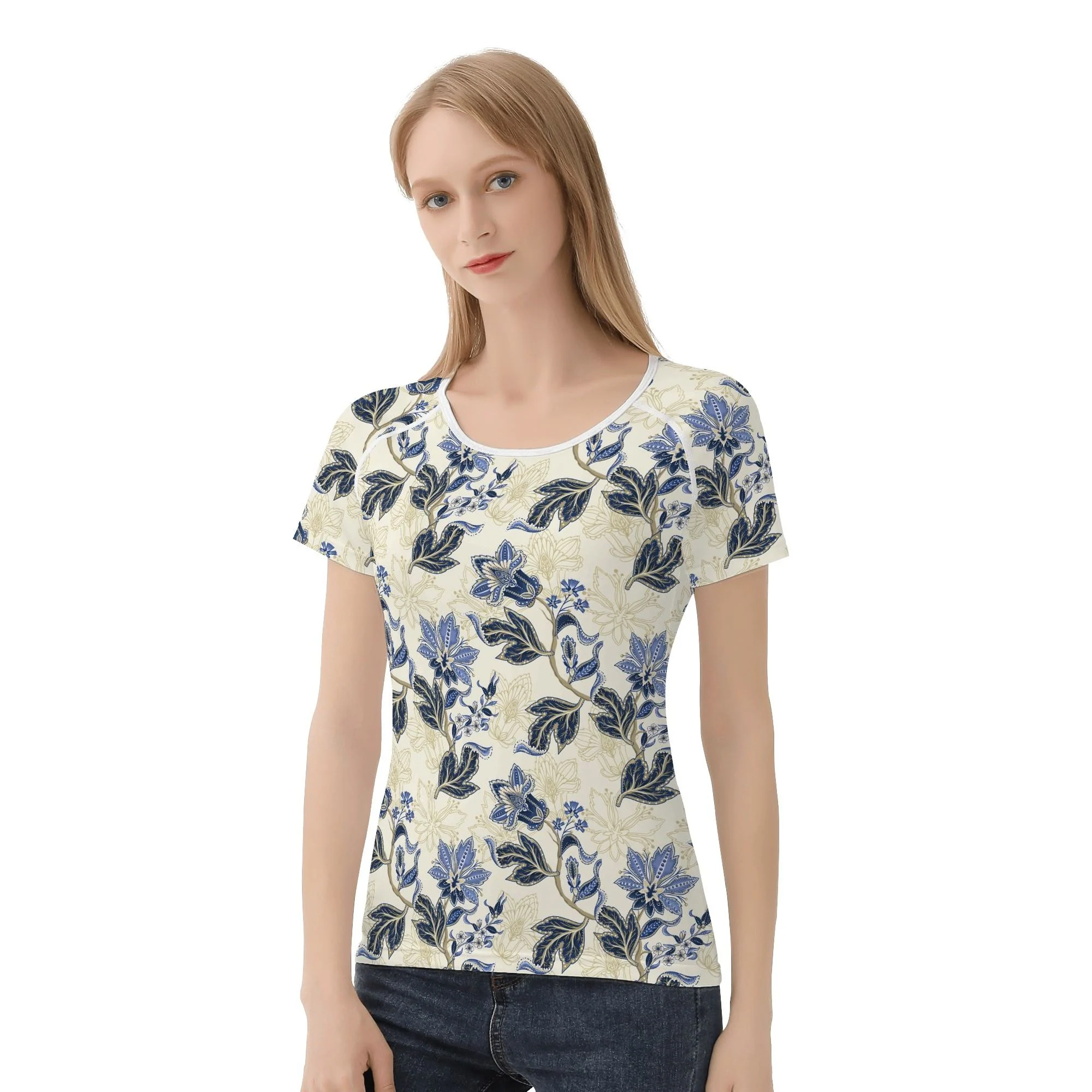 Camiseta de manga corta con estampado floral vintage en azul y dorado sobre fondo crema, mostrando costuras reforzadas y diseño único.