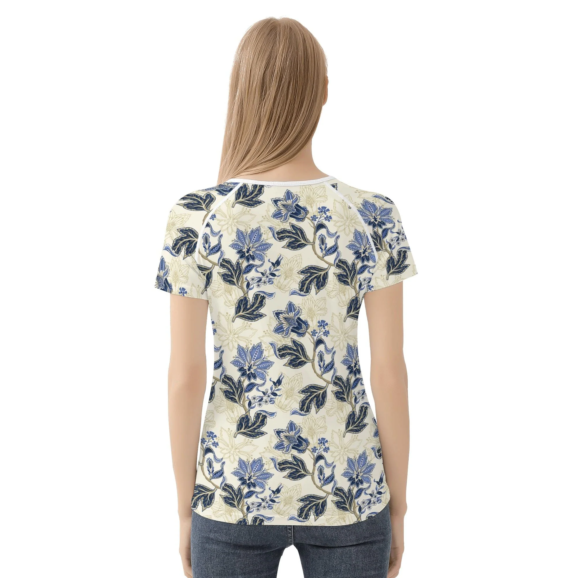 Camiseta de manga corta con estampado floral vintage en azul y dorado sobre fondo crema, mostrando costuras reforzadas y diseño único.