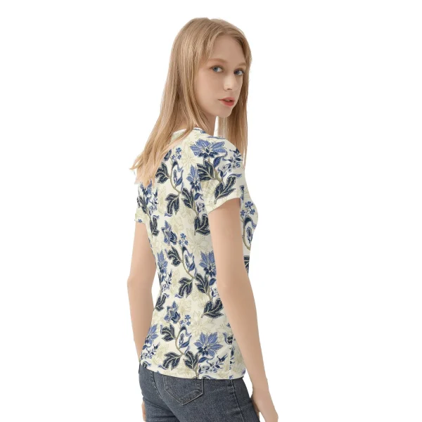 Camiseta de manga corta con estampado floral vintage en azul y dorado sobre fondo crema, mostrando costuras reforzadas y diseño único.