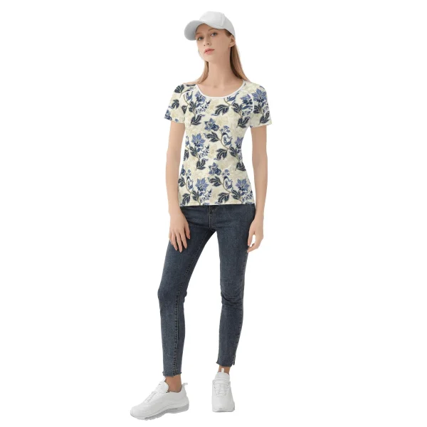 Camiseta de manga corta con estampado floral vintage en azul y dorado sobre fondo crema, mostrando costuras reforzadas y diseño único.