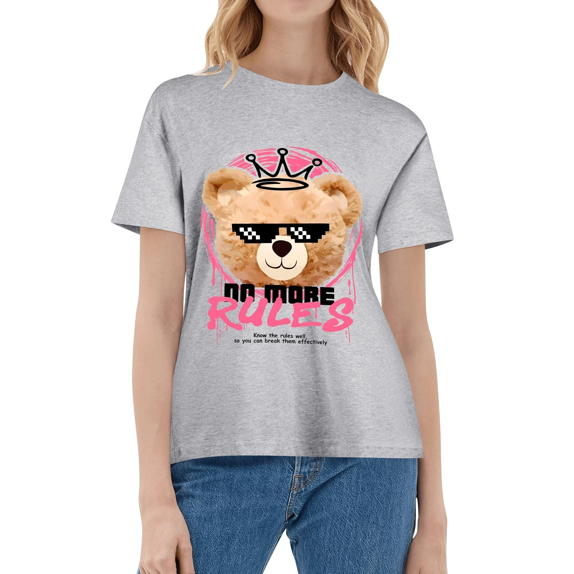 Camiseta blanca con estampado frontal de oso pixelado con corona y lema 'NO MORE RULES', en marco rosa y detalles de pinceladas.
