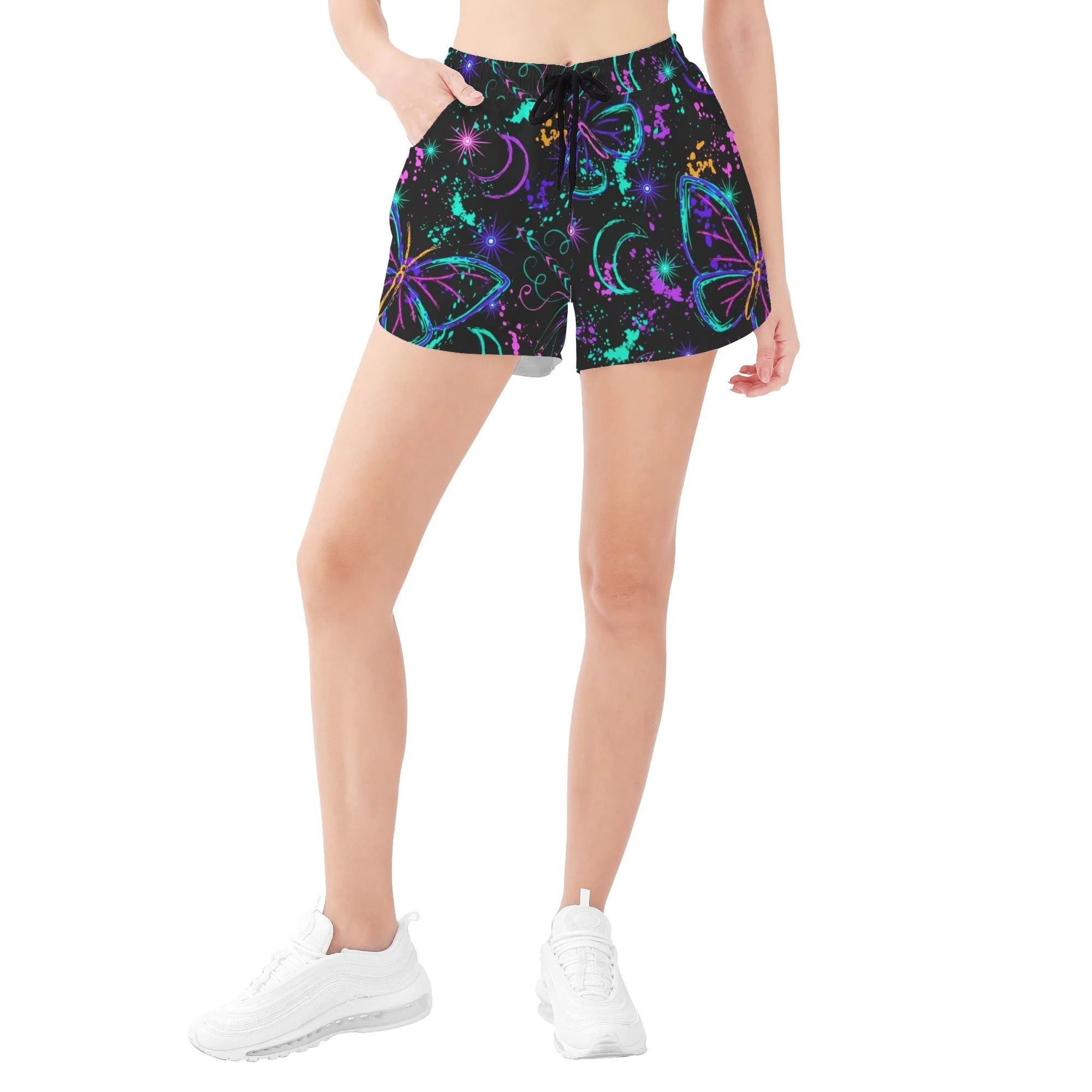 Shorts negros para mujer con estampado all-over de mariposas y libélulas neón, lunas crecientes y salpicaduras cósmicas.