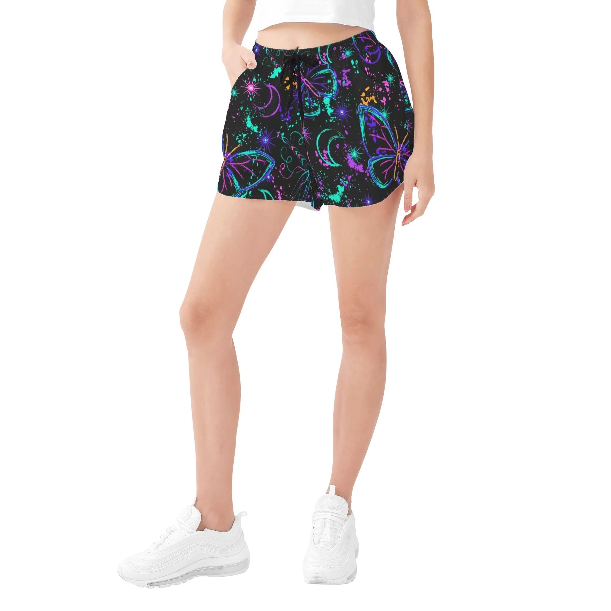 Shorts negros para mujer con estampado all-over de mariposas y libélulas neón, lunas crecientes y salpicaduras cósmicas.