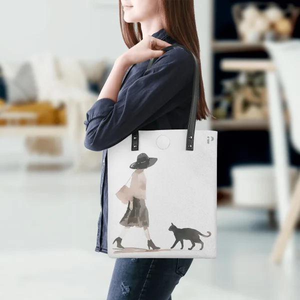 Bolso tote PU blanco con estampado de mujer paseando con gato en acuarela y tirantes negros.