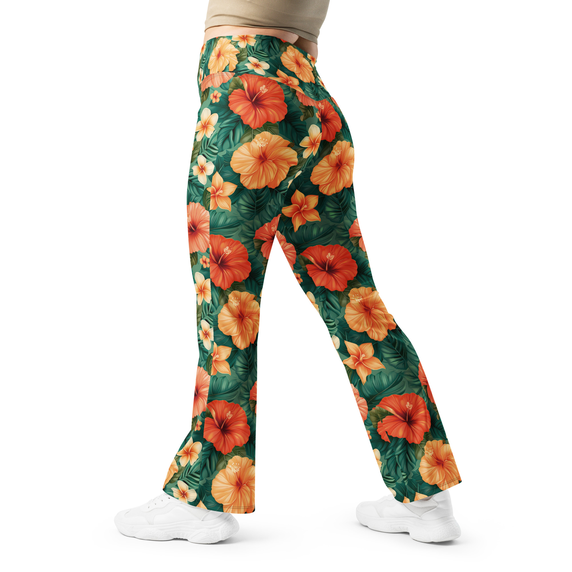 Mujer con leggins acampanados tropicales con flores hibisco rojas, naranjas y amarillas – colección Tropic – Heat.