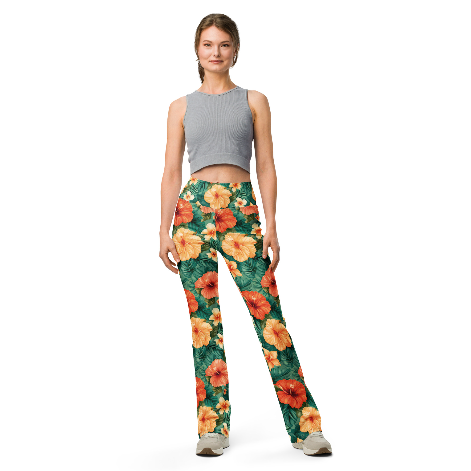 Mujer con leggins acampanados tropicales con flores hibisco rojas, naranjas y amarillas – colección Tropic – Heat.