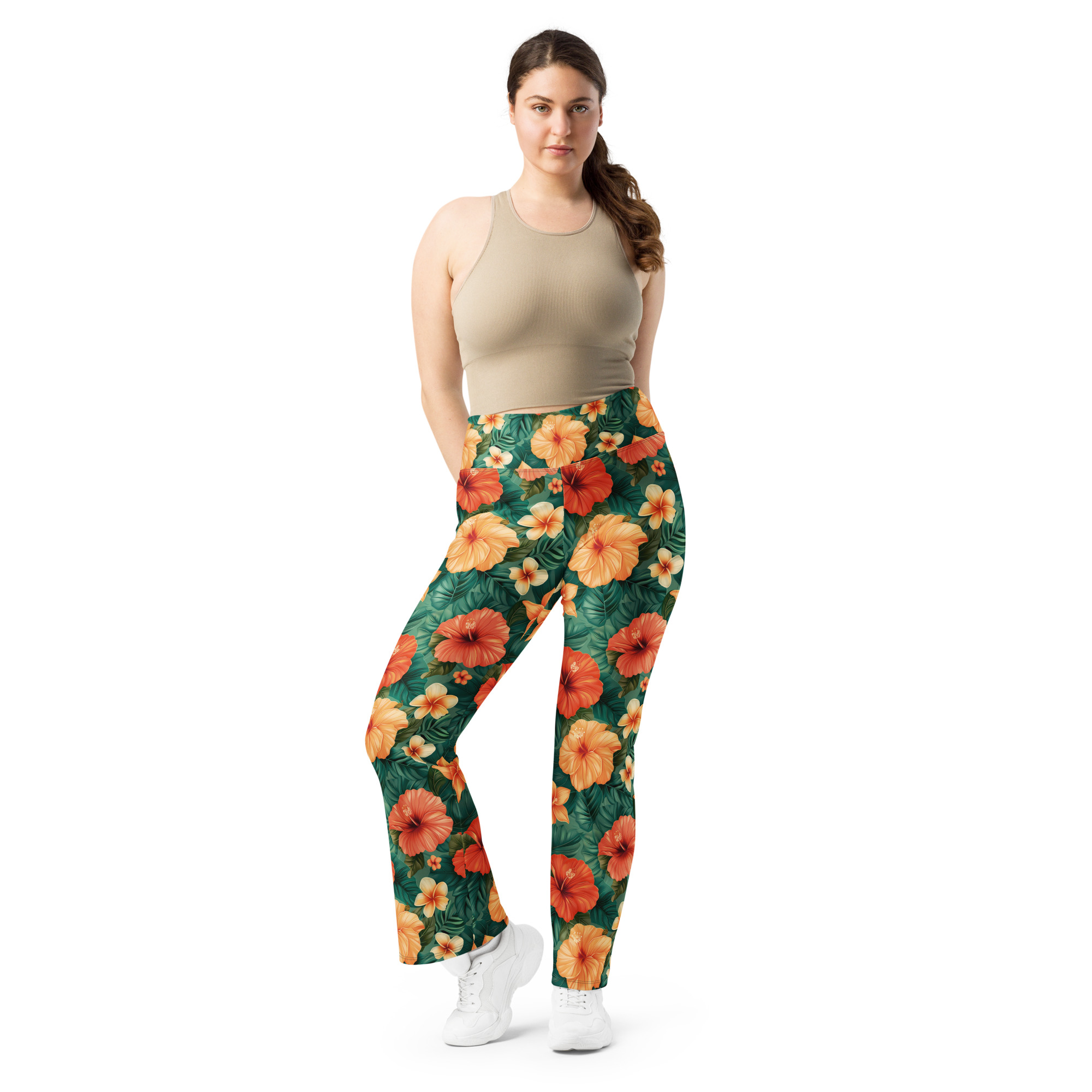 Mujer con leggins acampanados tropicales con flores hibisco rojas, naranjas y amarillas – colección Tropic – Heat.