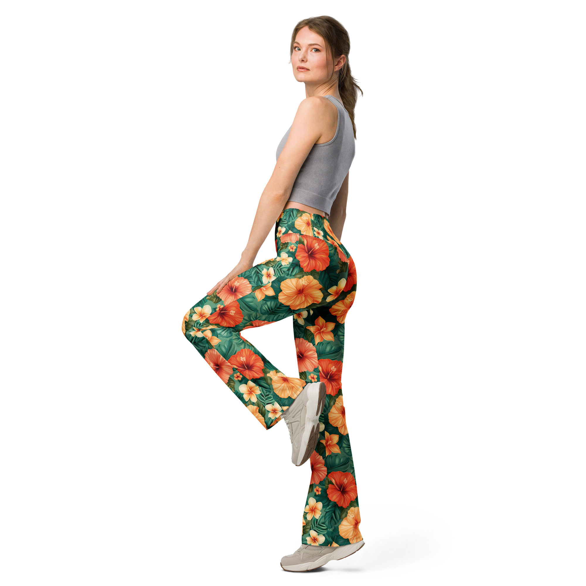 Mujer con leggins acampanados tropicales con flores hibisco rojas, naranjas y amarillas – colección Tropic – Heat.