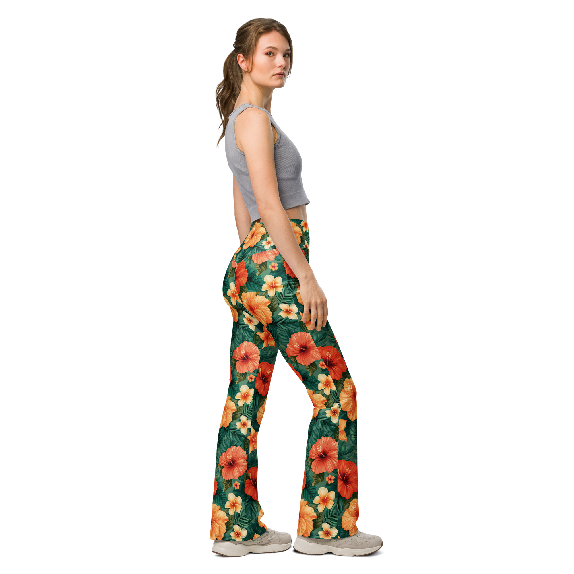 Mujer con leggins acampanados tropicales con flores hibisco rojas, naranjas y amarillas – colección Tropic – Heat.