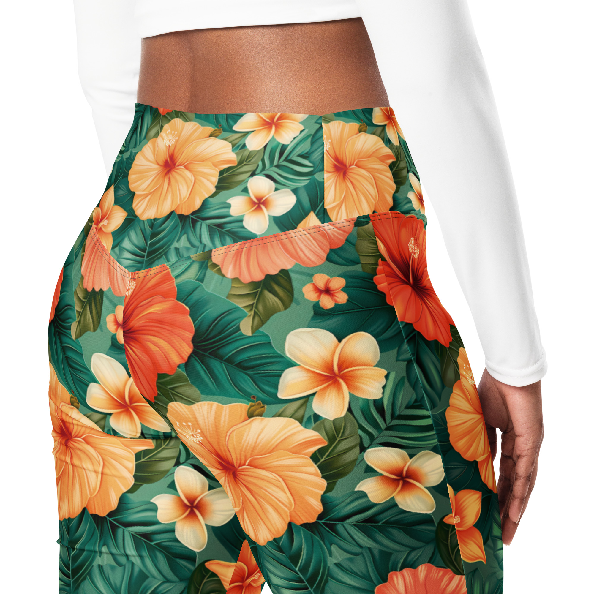 Mujer con leggins acampanados tropicales con flores hibisco rojas, naranjas y amarillas – colección Tropic – Heat.