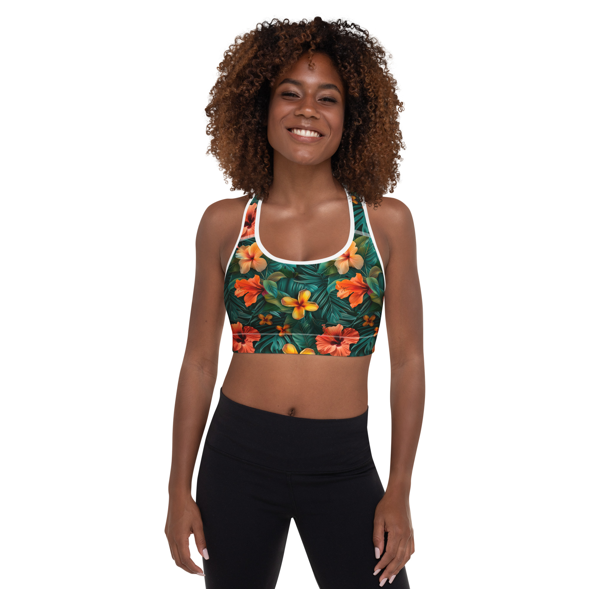 Mujer con sujetador deportivo tropical estampado integral en fondo oscuro, sonriente y en pose fitness