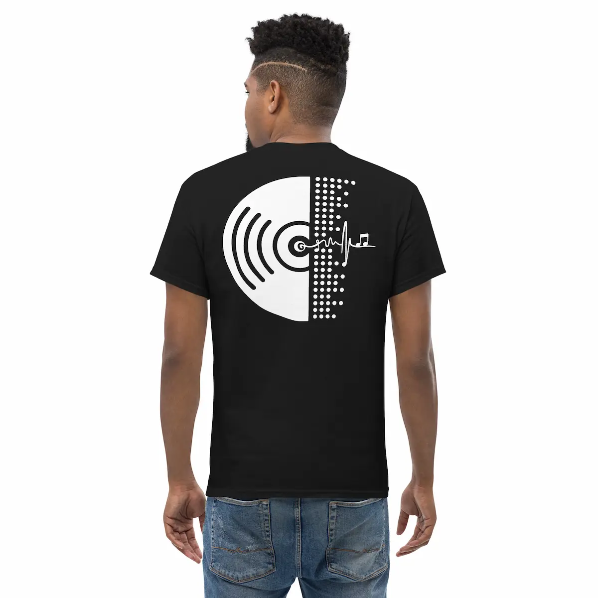 Modelo de espaldas con camiseta negra mostrando vinilo minimal en blanco; en el frontal, emblema heartbeat con nota musical.