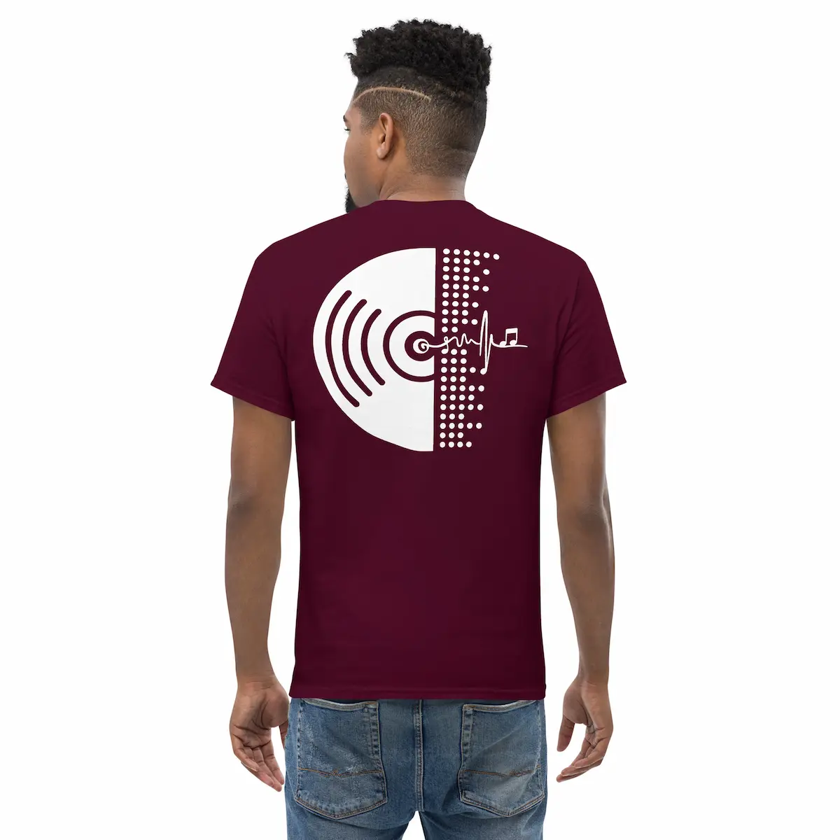 Modelo de espaldas con camiseta negra mostrando vinilo minimal en blanco; en el frontal, emblema heartbeat con nota musical.